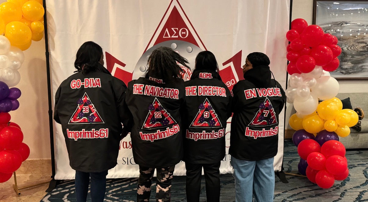 Four Sorors wearing black line jackets showcasing the back design 
